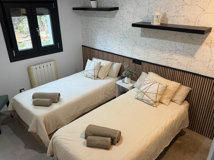 Dormitorio 2 con dos camas individuales, calefacción y toallas preparadas a la llegada.