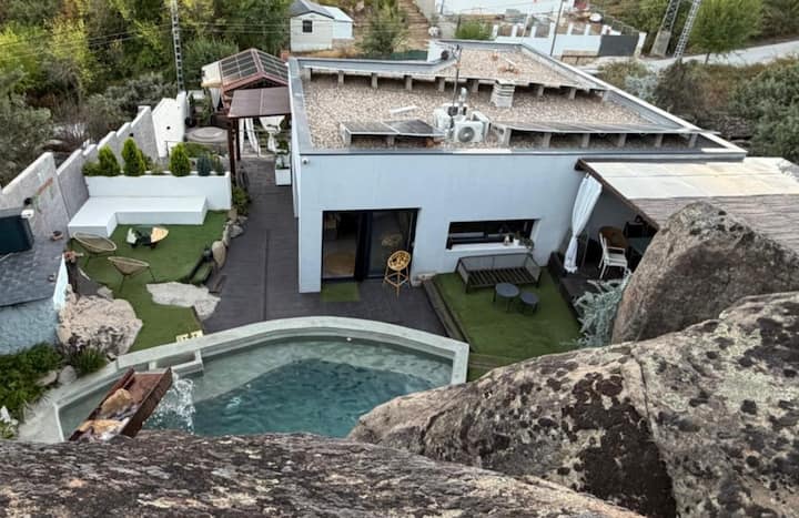 Vista aérea: piscina privada entre las rocas, climatizada y disponible todo el año.