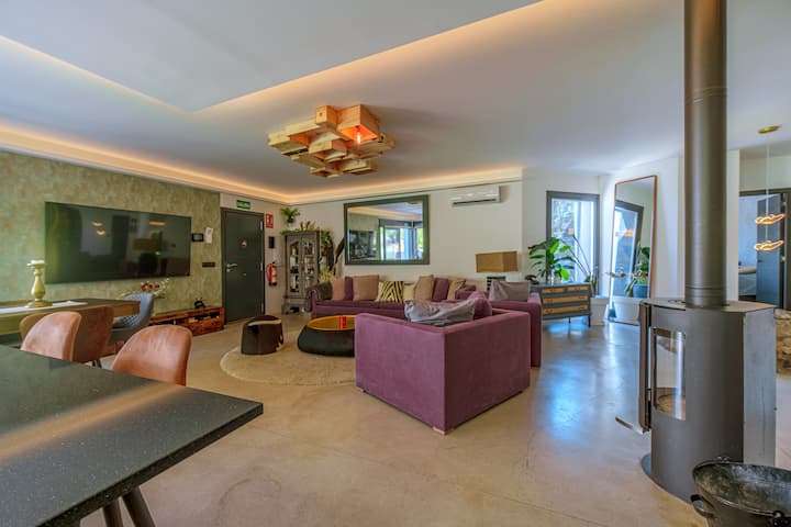 Salón panorámico con Smart TV y wifi, abierto al jardín por los ventanales.