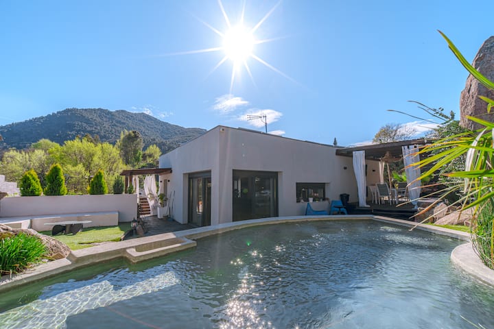 La piscina al sol con vistas a la sierra y tumbonas para todo el grupo.