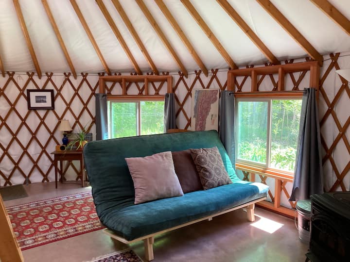 The futon offers a second sleeping option with views into the surrounding woods.