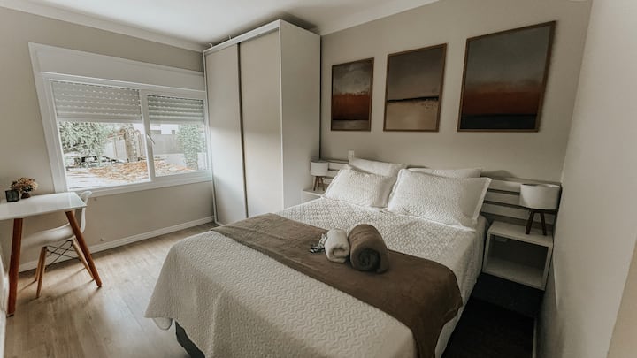 Აპარტამენტის სრული ხედი. საძინებელში ჰარმონიულად არის გაერთიანებული კომფორტული საწოლი, დიდი კარადა ბარგისთვის და სამუშაო ადგილი ფანჯრის ქვეშ. Ყველაფერი, რაც ერთ სივრცეში გჭირდებათ.