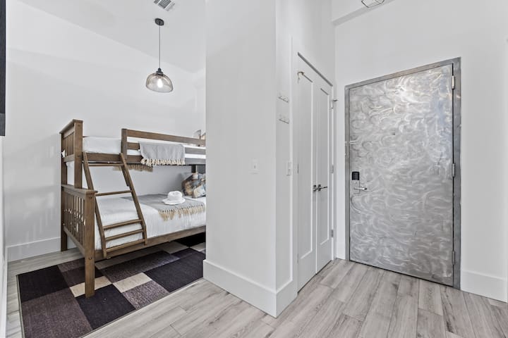 Útulná izba s poschodovou posteľou, pohodlnou posteľnou bielizňou a modernými prvkami.