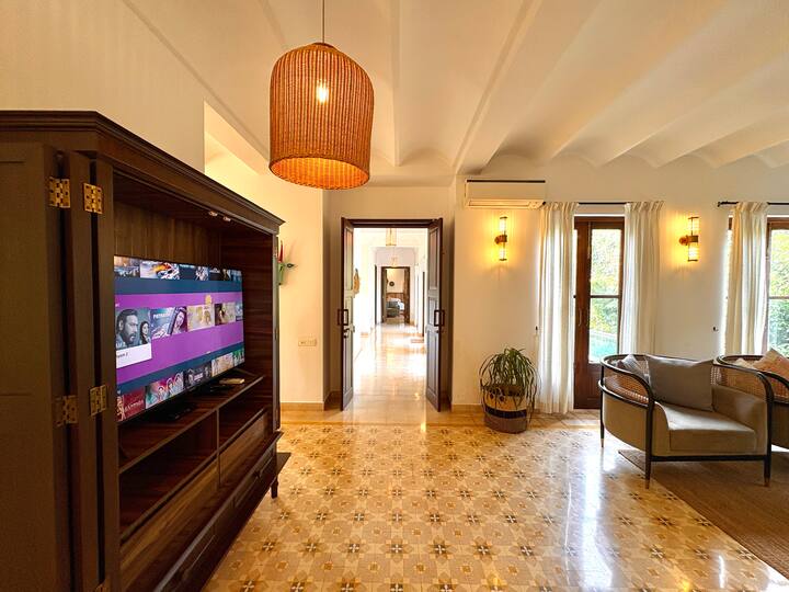 This spacious lounge features large wooden-framed windows that flood the room with natural light, creating a warm and inviting ambiance throughout the day.