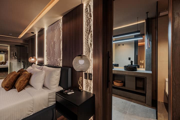 Este espacioso dormitorio cuenta con una cama tamaño king, vestidor, lámparas decorativas, detalles elegantes y baño privado. Una gran ventana llena la habitación de luz natural y ofrece una hermosa vista a la calle, creando un refugio moderno y sereno.