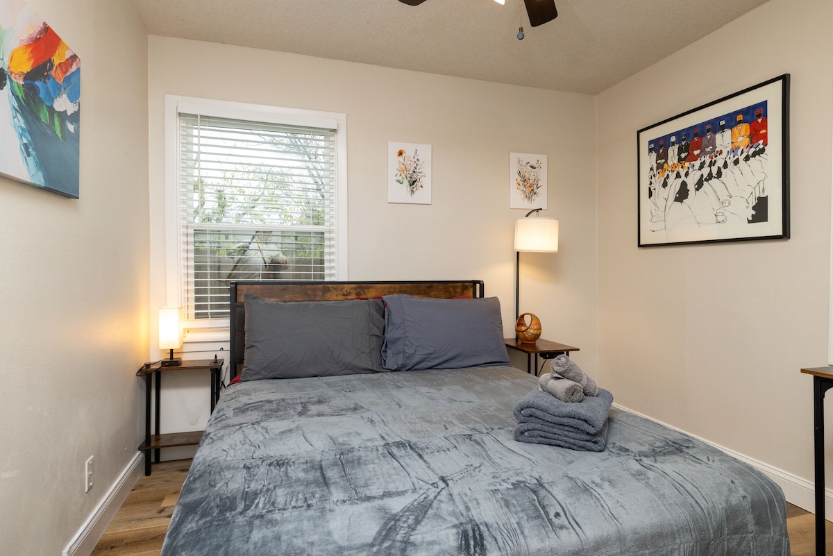 Útulná spálňa s mäkkou manželskou posteľou Queen, jemným osvetlením, moderným umením a vyhradeným pracovným priestorom. Pokojné a štýlové – ideálne na oddych alebo prácu.