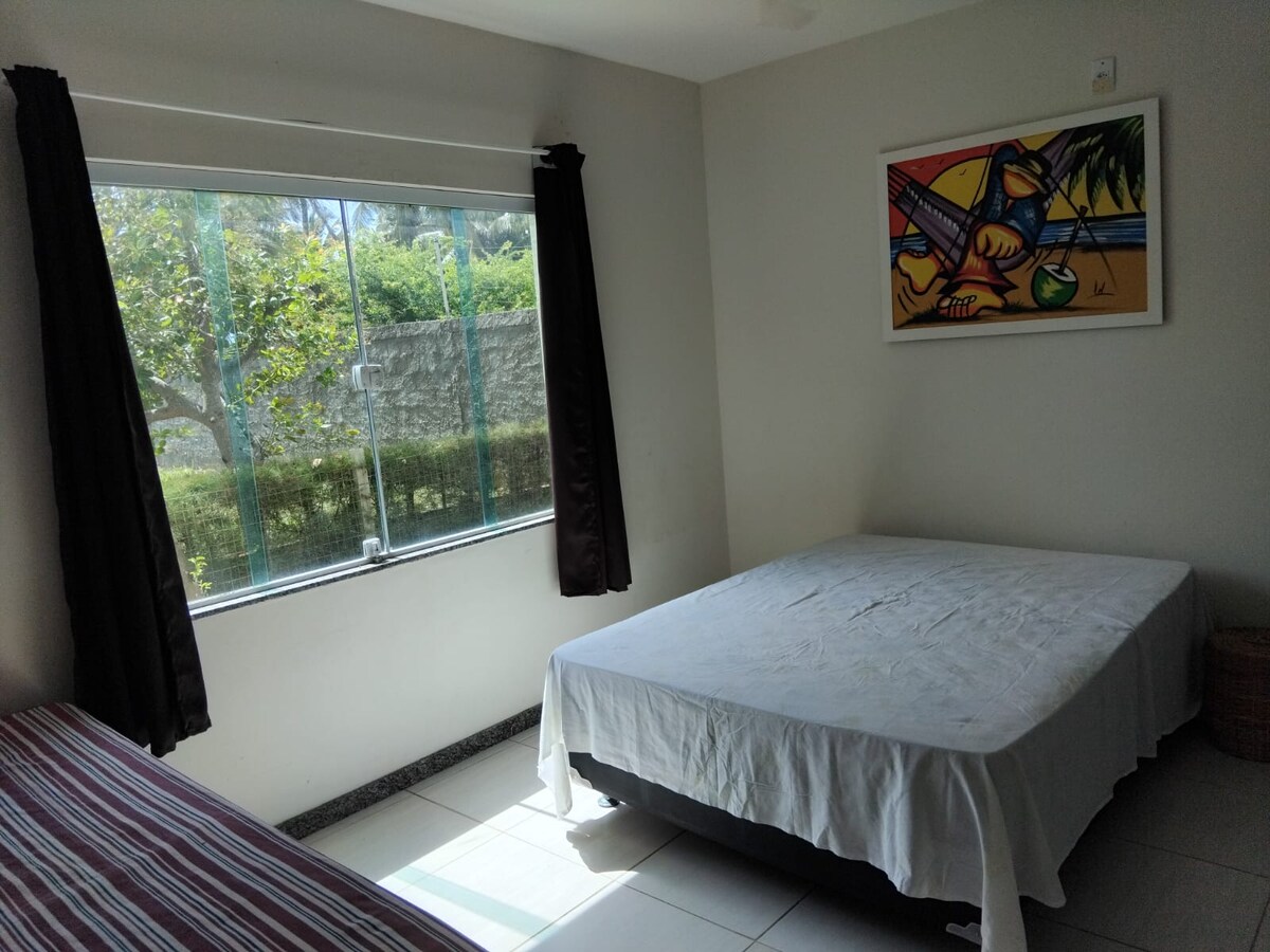 Chambre au rez-de-chaussée avec un lit double, un lit gigogne, une armoire et un ventilateur de plafond.