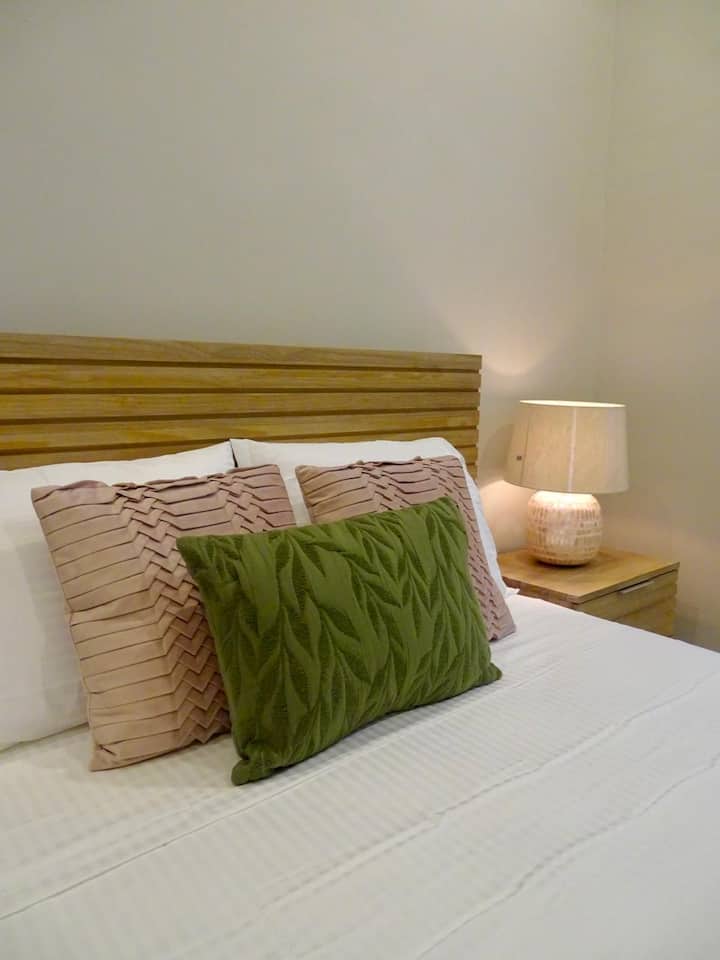 Second air-conditioned bedroom with queen bed and tropical surroundings.