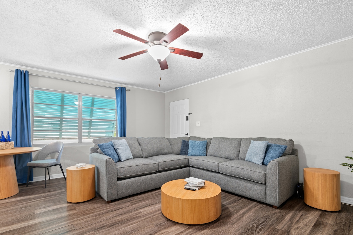 Svijetao dnevni boravak s udobnim kaučem i stropnim ventilatorom za opuštanje.