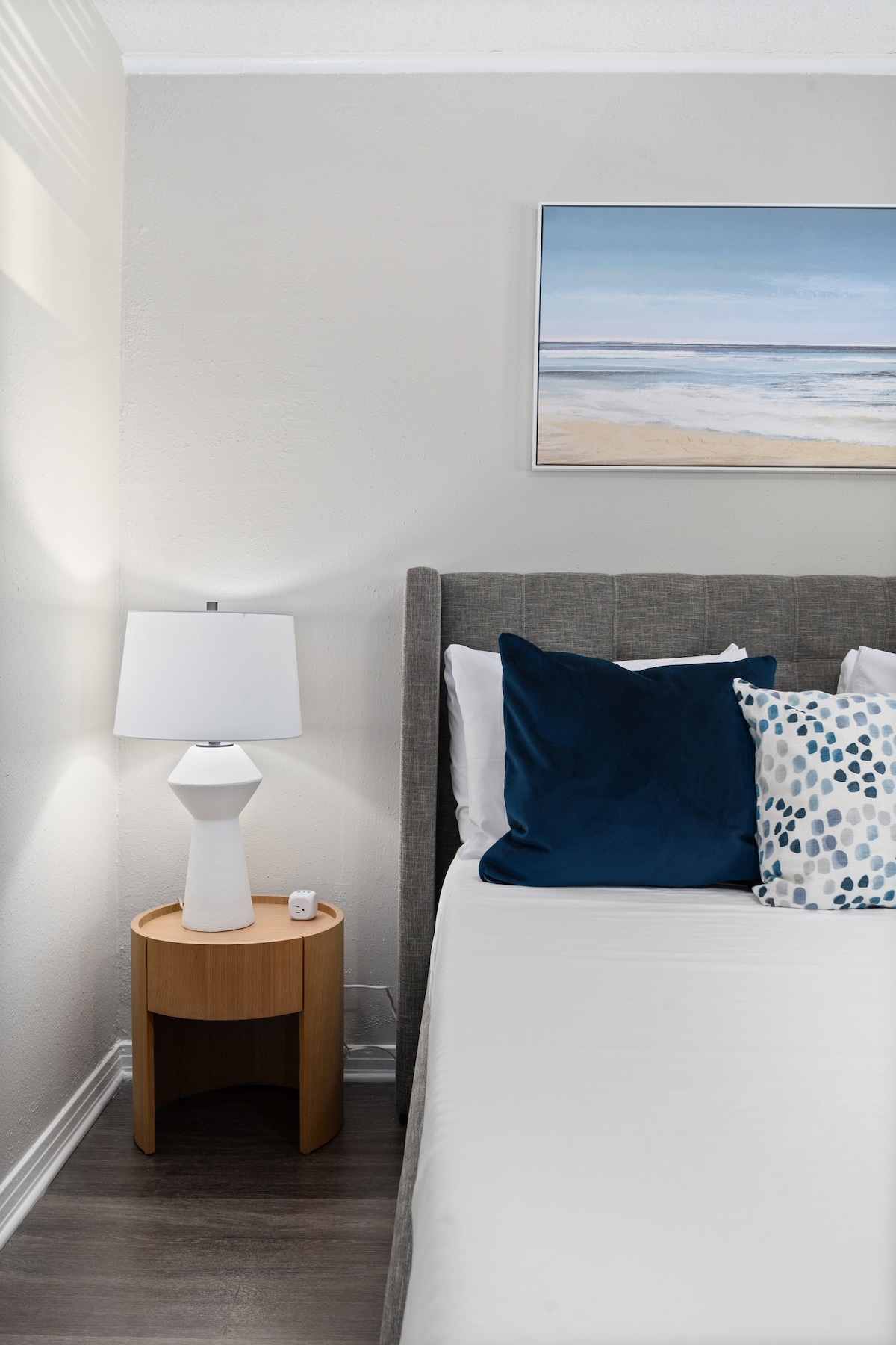 Mirni kutak u spavaćoj sobi s noćnom lampom i svježom posteljinom za miran boravak.