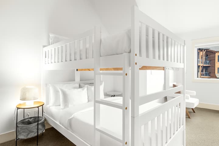 Rummeligt køjesoveværelse med to queensize-senge.