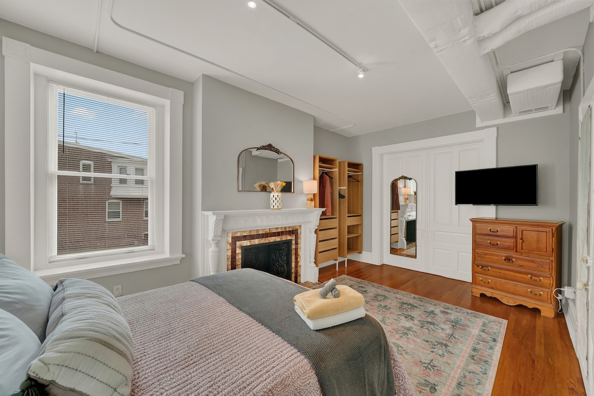 חדר השינה כולל ארון בגדים תלוי, שידה וטלוויזיה חכמה.