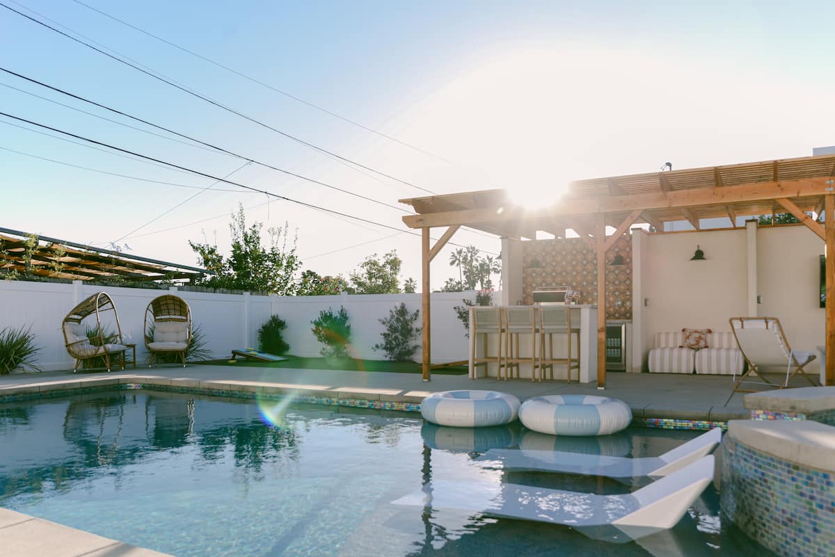 The heated saltwater pool, egg chairs and pergola in the backyard at The Sapphire in Pacific Beach, designed by Salt and Sky Lodging Co.