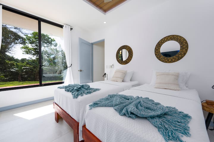 Acogedor dormitorio con dos camas individuales que se pueden convertir en una cama tamaño king, un baño privado y un televisor. Ideal para parejas, amigos o huéspedes más jóvenes que quieren un lugar cómodo para relajarse.