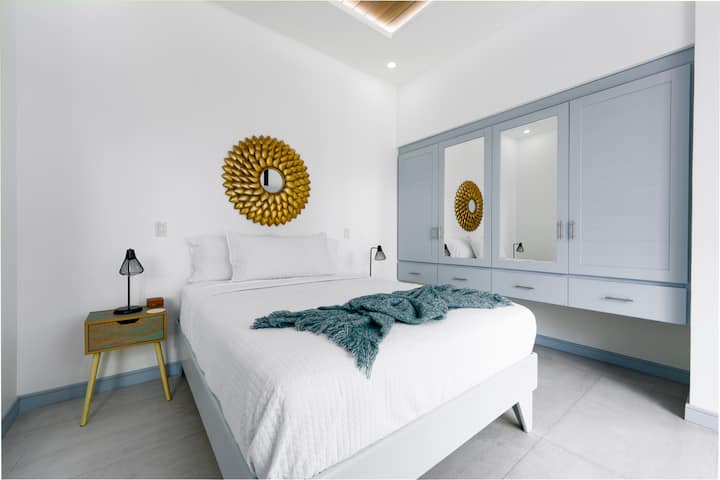 Tranquilo dormitorio tamaño queen con baño privado y balcón propio con vistas a la selva y las montañas. Disfruta del café de la mañana o de las brisas del atardecer desde la mecedora, tu propio refugio tranquilo en Casa Sunset.