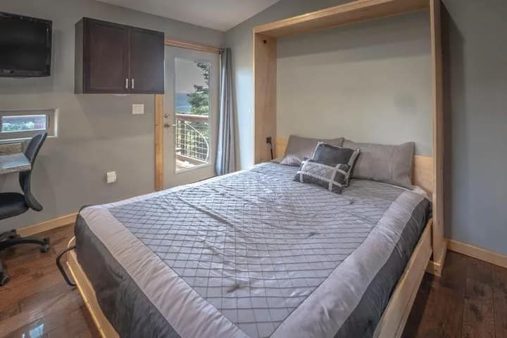 Guest room with balcony access and valley views. Step out to fresh mountain air, then settle at the desk with coffee. Watch for hummingbirds and Steller's jays in the pines, with quiet nights after ski days and sunset dinners at RidgeWalk Lodge.