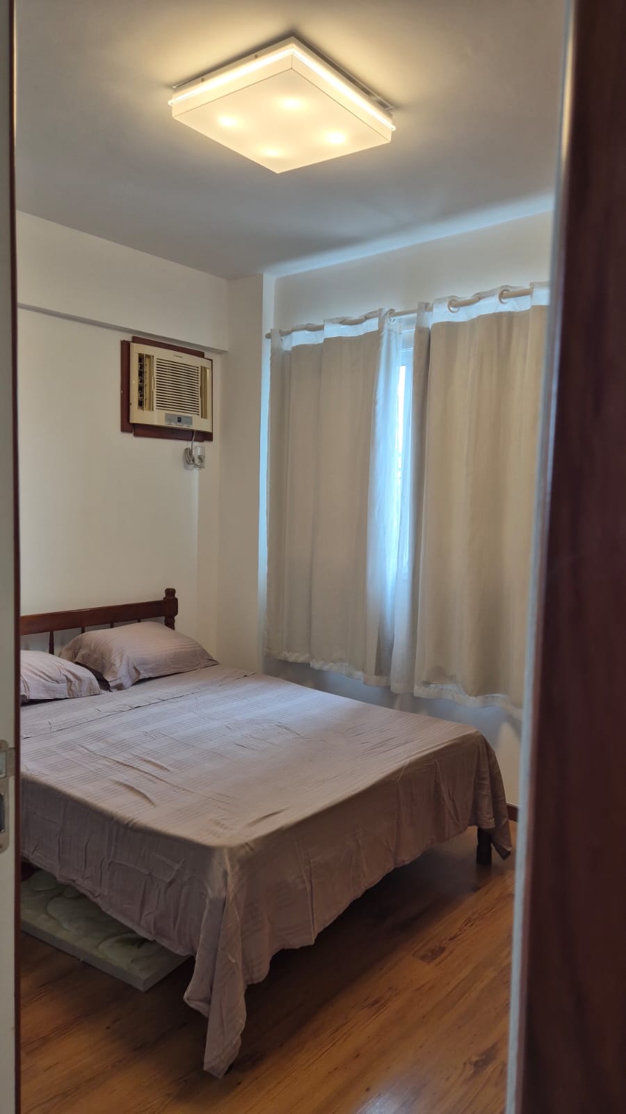 חדר שינה 02 עם מיטה זוגית, ארונות, וילון ומיזוג אוויר.