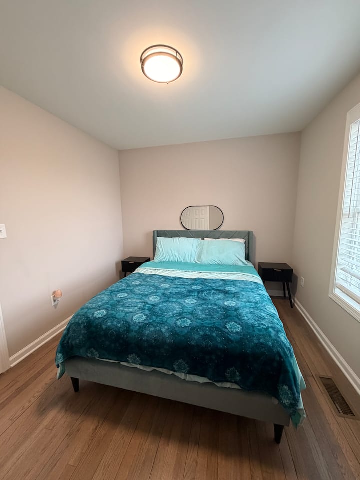 בחדר השינה עם מיטת קווין סייז בקומה הראשית יש טלוויזיה ושולחן לעבודה 