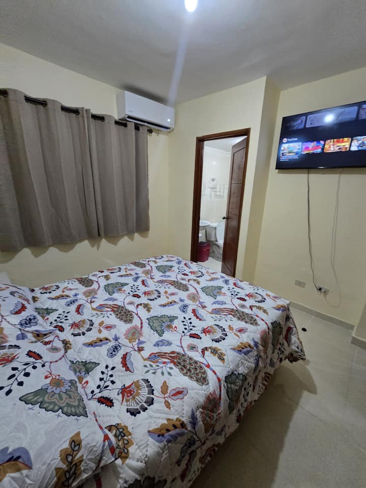 ห้องนอนใหญ่ที่อบอุ่นพร้อมเตียงคู่ เหมาะสำหรับการพักผ่อนอย่างเต็มที่ มีเครื่องปรับอากาศ สมาร์ททีวีติดผนัง และม่านทึบเพื่อความเป็นส่วนตัวและการนอนหลับอย่างไม่ถูกรบกวนตลอดเวลา”