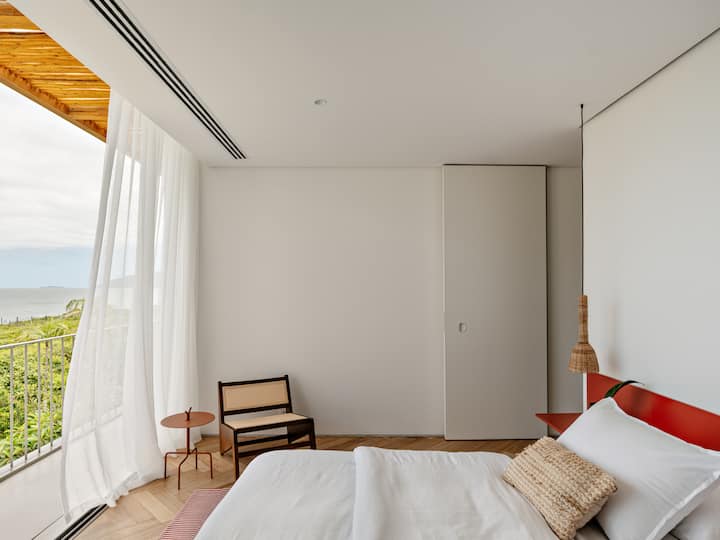 Two master bedrooms with sea view, balcony, air conditioning, mosquito net, king size bed and different pillow heights.