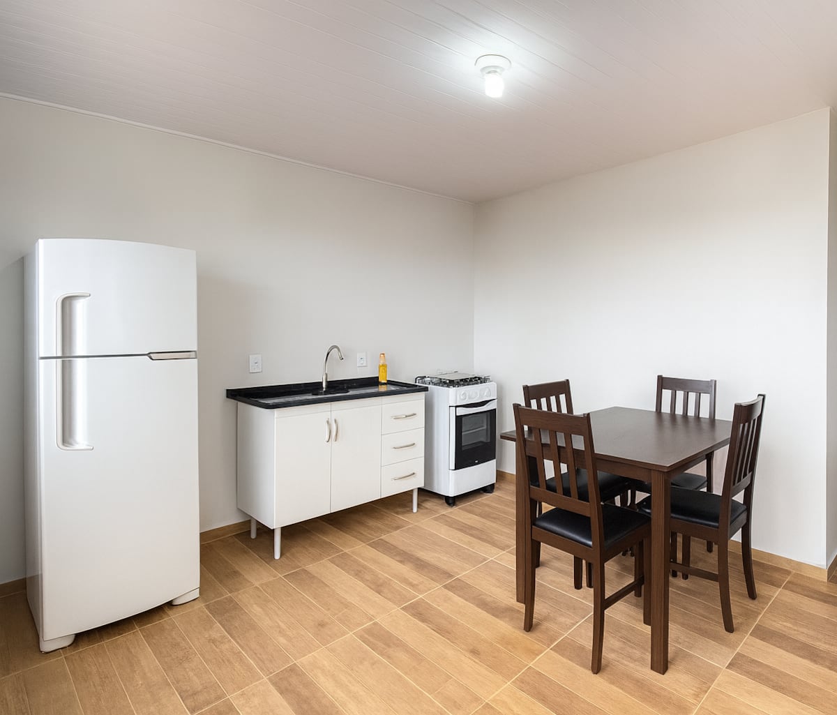 Cozinha completa de apartamento Airbnb em Cascavel, com armários, bancada e eletrodomésticos para uso diário.
