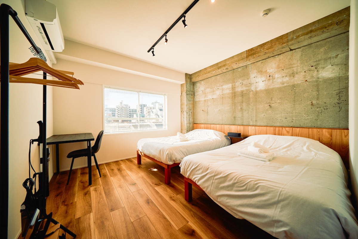 【寝室2】セミダブルベッド2台とデスクを備え、4名まで就寝可能な広めのメインベッドルームです。