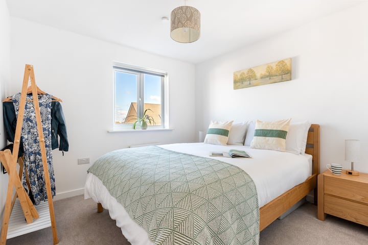 Lovely light-filled king bedroom featuring a clothes hanger and luggage rack.
