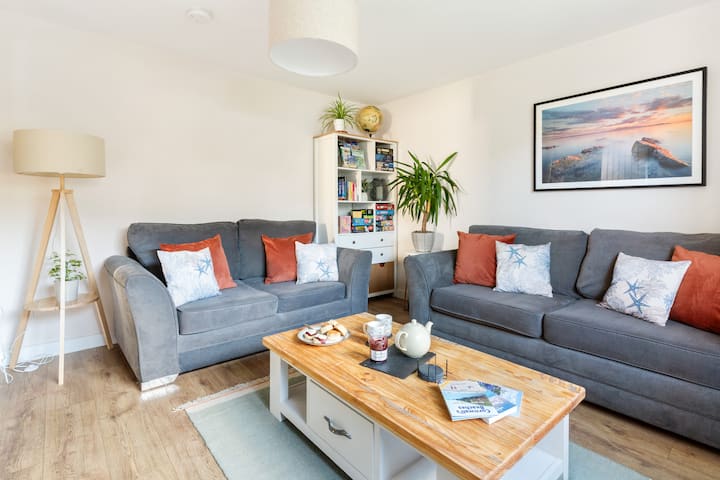 The cosy living room with two sofas, board games and TV