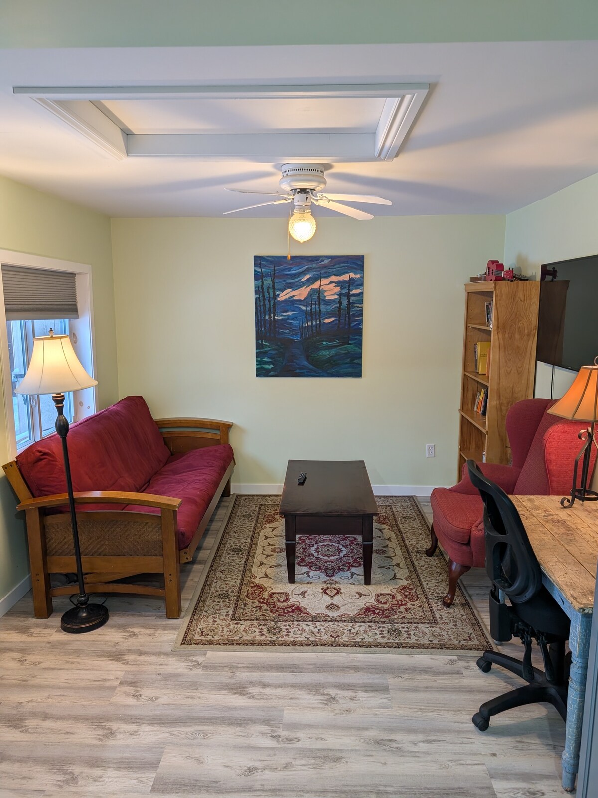 Sala de estar con sofá futón que se pliega hasta convertirse en cama