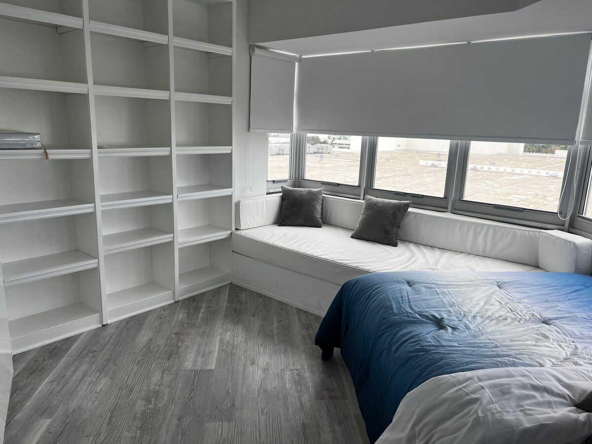 מיטת קווין סייז עם חדר רחצה צמוד. דלתות הזזה יוצרות חדר פרטי וחדר רחצה צמוד.