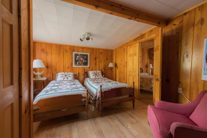 Chambre à coucher double : avec des couettes classiques et des tons de bois chauds, parfaite pour les enfants ou les invités supplémentaires.