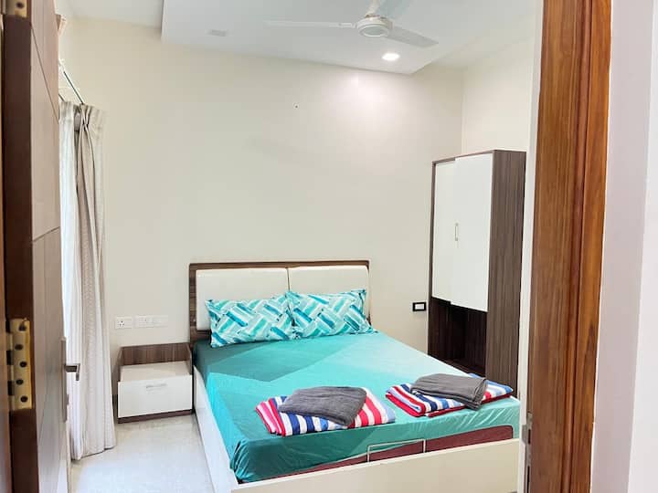 El dormitorio está equipado con cama doble con 2 almohadas, mesa auxiliar, unidad de almacenamiento y ventilador de techo.