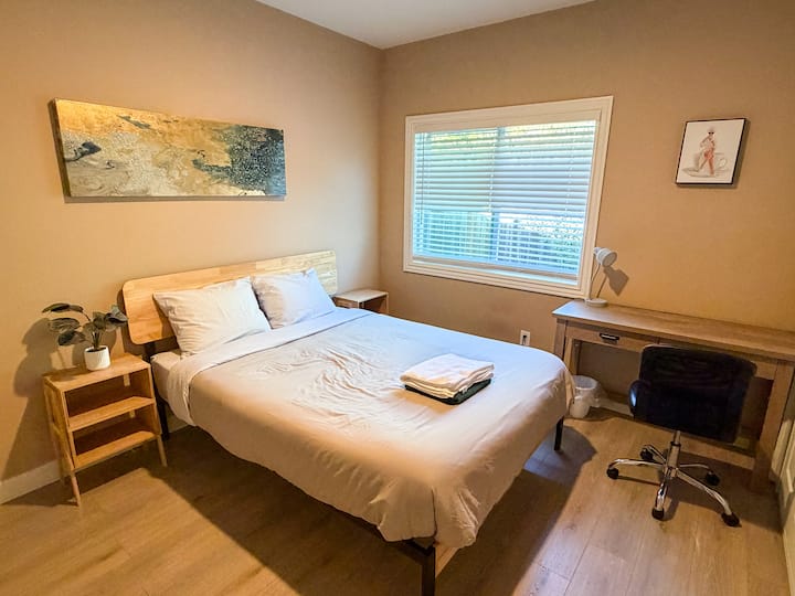 מיטת קווין סייז עם פינת עבודה ייעודית ואור טבעי.