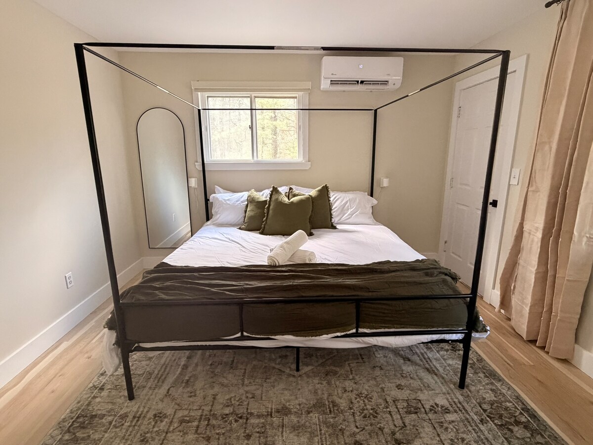 ห้องนอนหลักพร้อมเตียงคิงไซส์ ผ้าปูที่นอนสะอาด และบรรยากาศที่สงบและผ่อนคลาย