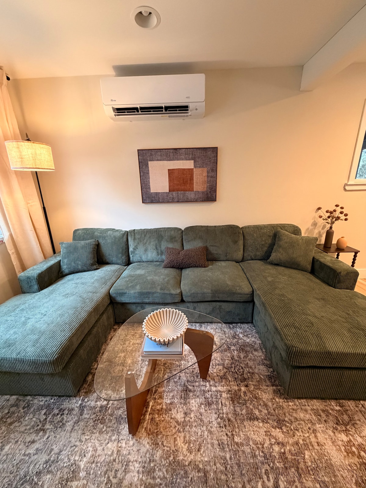 ห้องนั่งเล่นกว้างขวางพร้อมโซฟาขนาดใหญ่ พรมพื้นที่นุ่ม และแสงสว่างอบอุ่น เหมาะสำหรับการพักผ่อนด้วยกันหลังจากสำรวจมาทั้งวัน