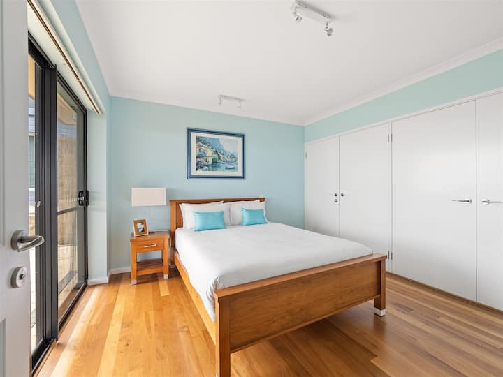 Los tonos cálidos y la luz natural suave hacen de este dormitorio tamaño queen en el primer piso un refugio tranquilo durante tu estancia.