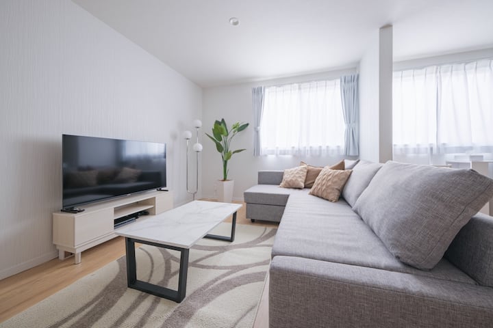 It is a spacious living room with a comfortable sofa