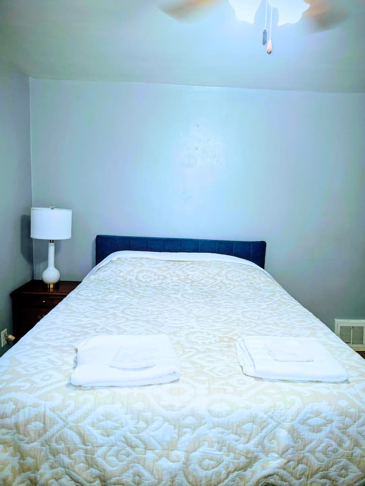 Cama queen cómoda con tocador, mesita de noche, escritorio para computadora, lámpara, silla, alfombrilla, ventilador de techo y luces potentes para su comodidad.  Una puerta trasera para acceder al balcón y disfrutar del aire fresco y la relajación. 
