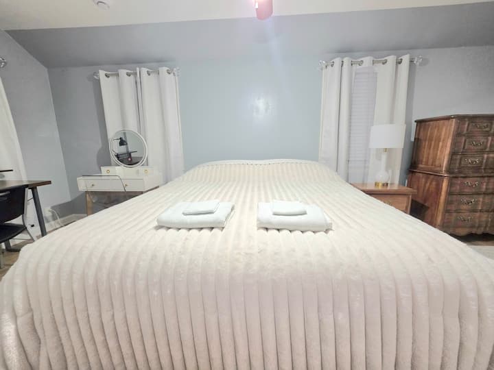 Hermoso dormitorio principal con una cómoda cama king, 2 armarios con perchas, 2 tocadores, mesita de noche, tocador de belleza, escritorio para computadora, lámpara, silla, alfombra y ventilador de techo con luces brillantes para su comodidad y disfrute. 