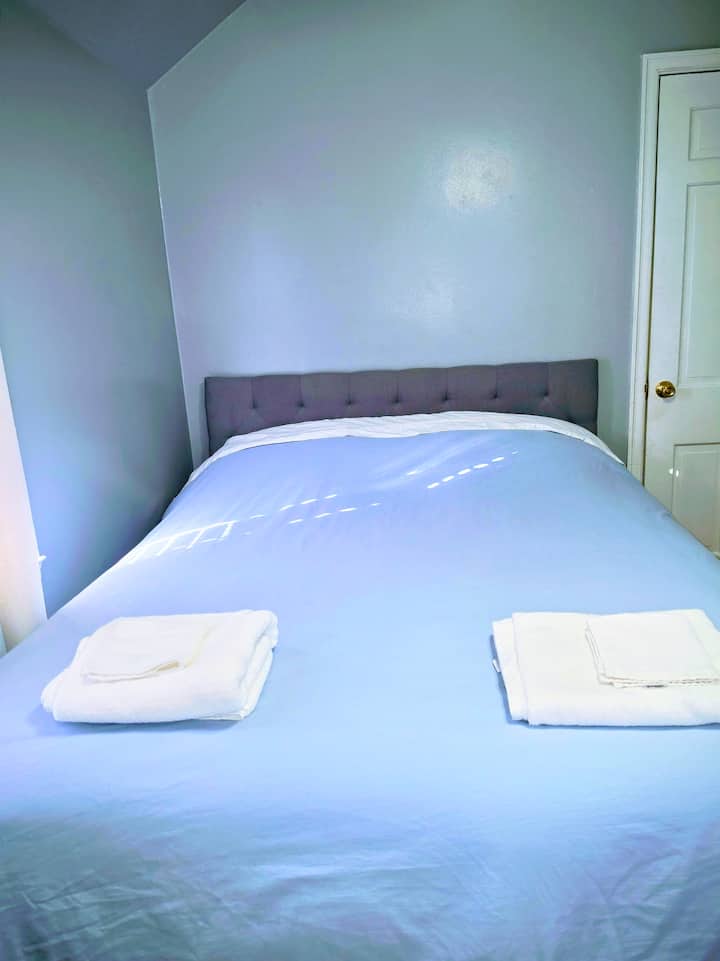 Cama queen cómoda con tocador, mesita de noche, escritorio para computadora, lámpara, silla, alfombrilla, ventilador de techo con luces brillantes y un armario con perchas para su comodidad y relajación. 