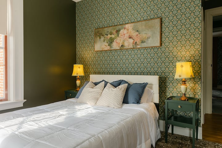 Dormitorio tamaño queen con carpintería original y vistas a la colina. Cada uno de los 4 dormitorios cuenta con ropa de cama de calidad hotelera y toques de diseño boutique.