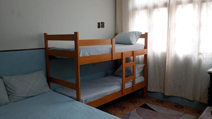 Spavaća soba 1 sadrži krevet na kat, bračni krevet i TV. 