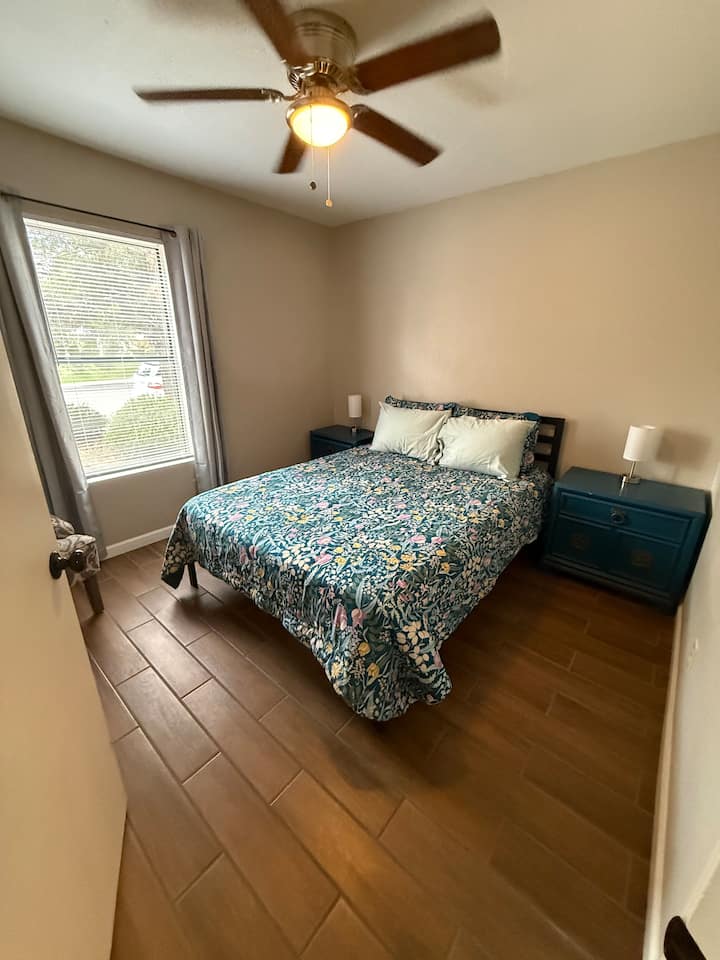 Queen size bed, nightstands, lamps, and extra seating and ceiling fan with light