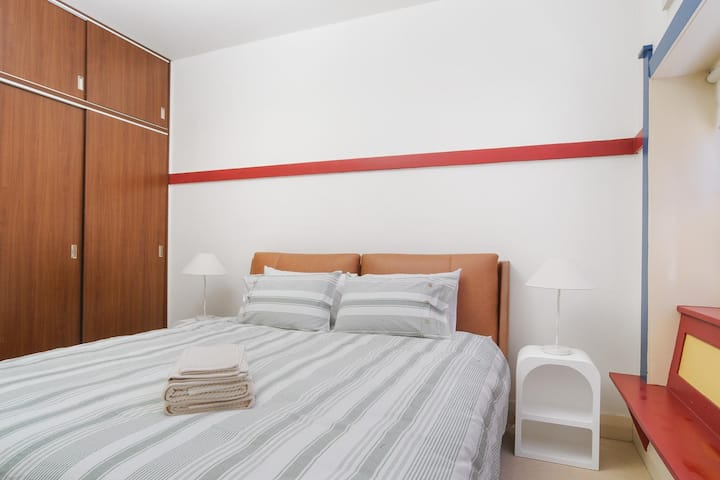 غرفة نوم بحجم كوين مع خزانة ملابس مدمجة وإضاءة بجانب السرير