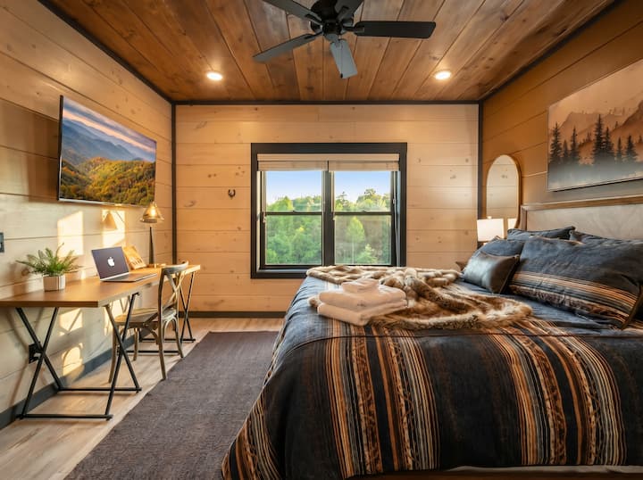 King Suite 2 - Entry level bedroom with private ensuite bathroom, Dedicated Workspace, Smart TV, Couch, Closet and Ceiling fan.