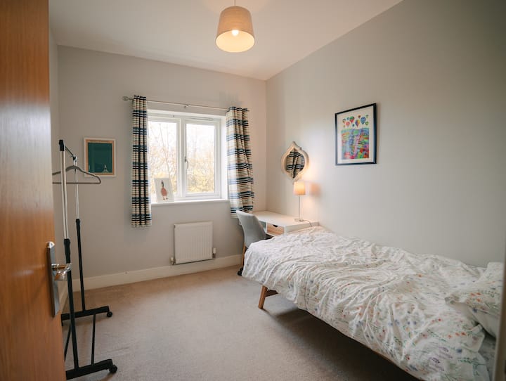 Krevet za jednu osobu, radni stol i stolica, šipka s vješalicama. 