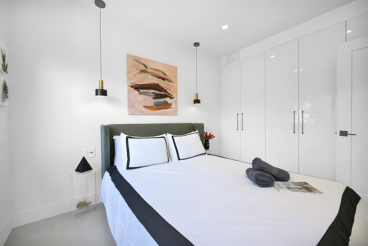 Dormitorio moderno y limpio con iluminación suave, decoración de diseño y amplios armarios empotrados.