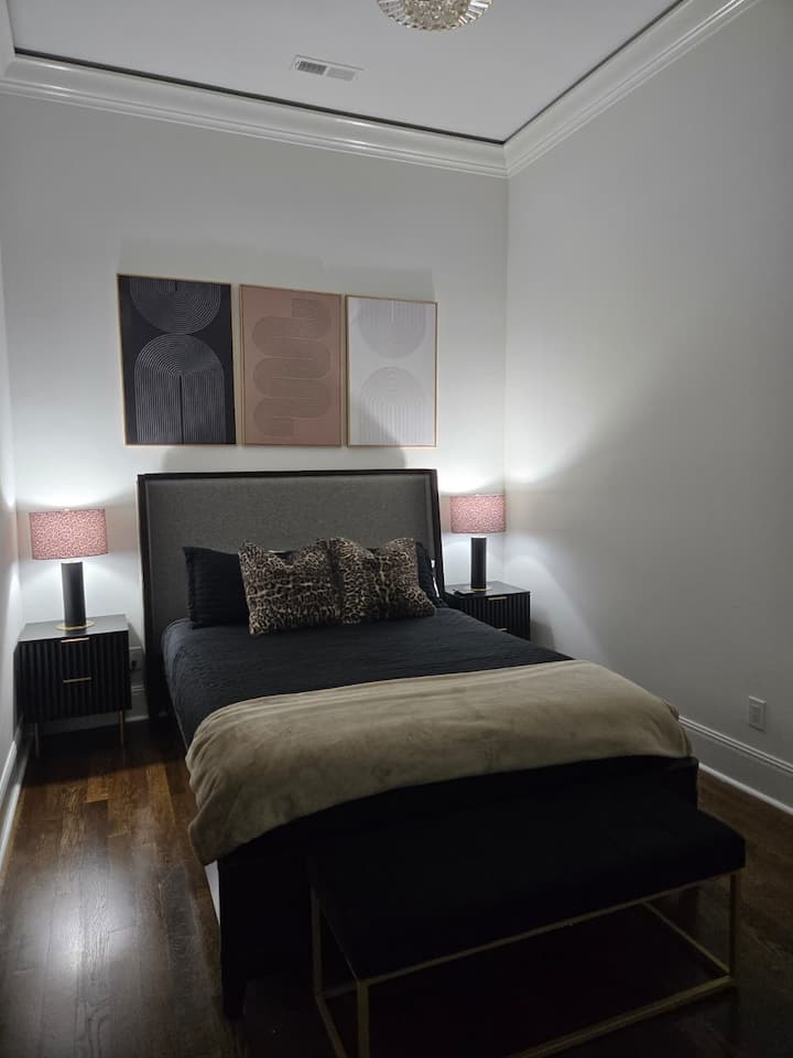 Queen bedroom with flatscreen TV. The ceiling light has a fan activated by a remote.