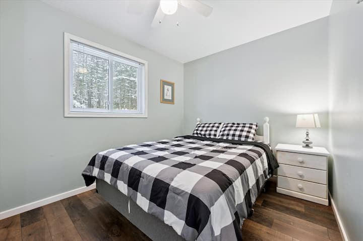 Bedroom 1: Bright and comfortable bedroom featuring a queen bed and tranquil forest outlook