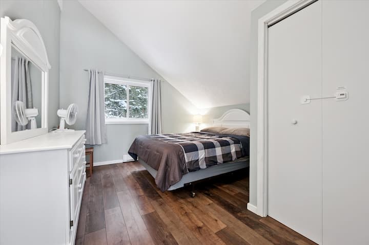 Bedroom 2: Cozy upstairs bedroom with queen bed, vaulted ceiling, and peaceful woodland views